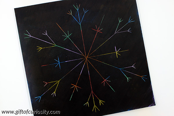 Snowflake scratch art using DIY scratch paper made with Kwikstix Thin Stix. I can't believe how easy and mess-free it is to make scratch paper with these solid tempera paints! And the snowflake art looks beautiful. This is a great winter art project to try with the kids. || Gift of Curiosity