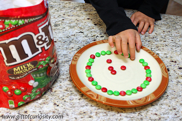 Grow a candy Christmas wreath this December with this Christmas STEAM that will wow not just the kids but the grownups too! This activity combines art, dissolving science, and fine motor skills into one exciting experience kids will love. || Gift of Curiosity