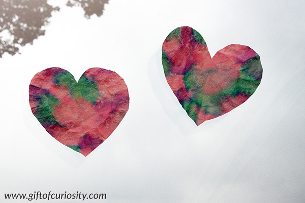 Heart suncatcher craft for Valentine's Day made from coffee filters and liquid watercolor paints #ValentinesDay #hearts || Gift of Curiosity