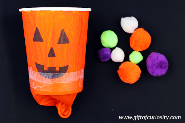 Pumpkin poppers Halloween STEAM activity: This Halloween activity blends art and engineering to create a fun pumpkin popper that "pops" out pom poms! | #STEAM #Halloween #handsonlearning #giftofcuriosity || Gift of Curiosity