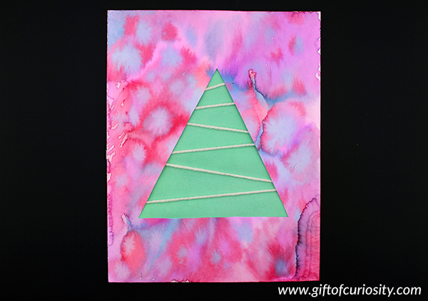 Kids of all ages will enjoy making these adorable Christmas trees with yarn "snow." This craft is really flexible in terms of the materials you use to make the tree and the colored overlay. The only "must have" item for this craft is white yarn. Use this craft to experiment with different colors, drawing mediums, and art techniques. #artsandcrafts #Christmas #giftofcuriosity || Gift of Curiosity